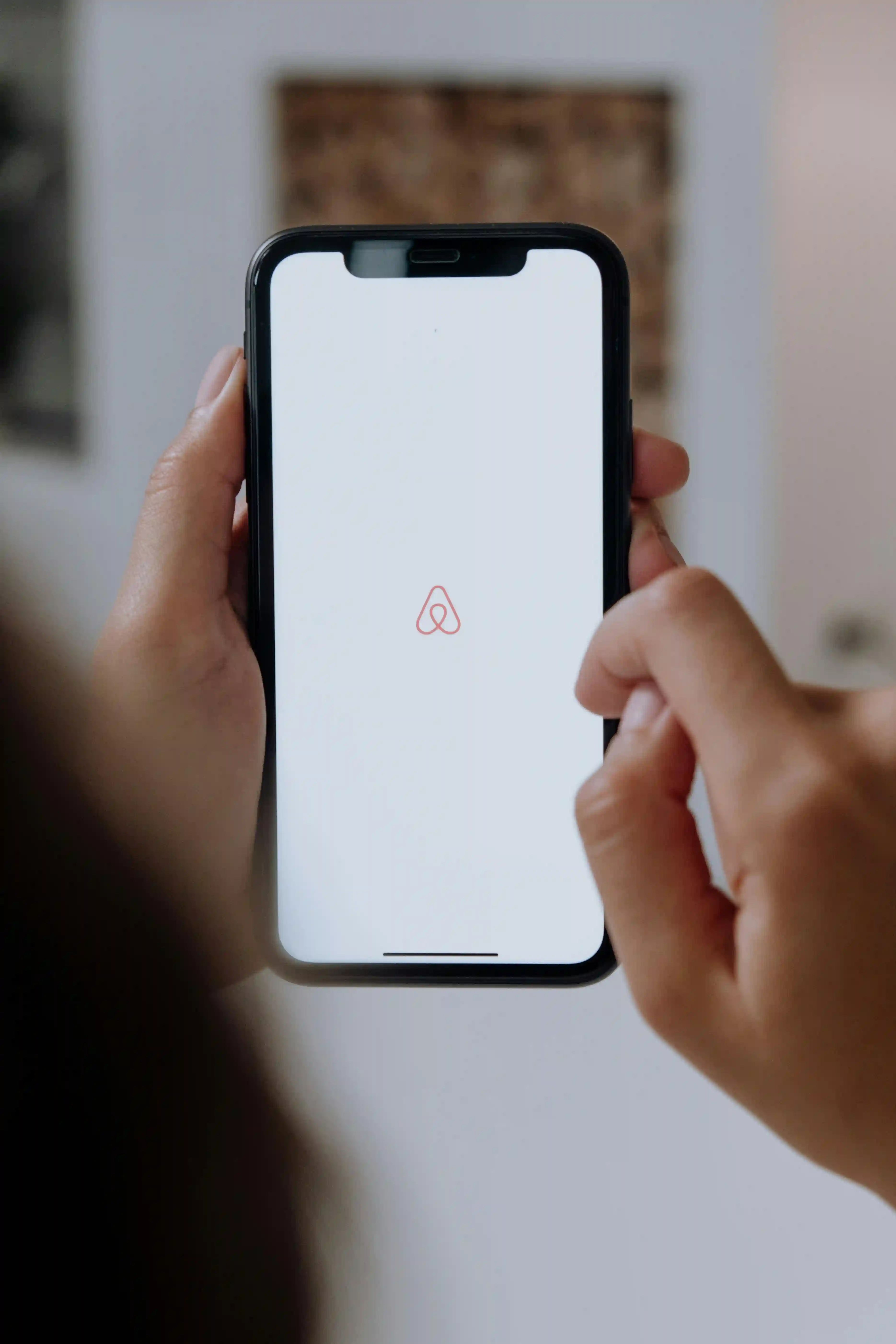 Application Airbnb ouverte sur un téléphone, illustrant la gestion des locations saisonnières par Halo Butler.