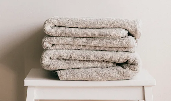 équipements indispensables Airbnb - détail de la literie et des serviettes dans une chambre