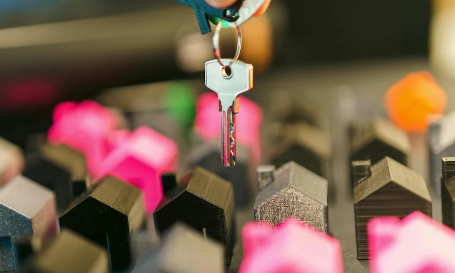 Clé de maison au-dessus de plusieurs logements, illustrant l’investissement locatif géré par Halo Butler